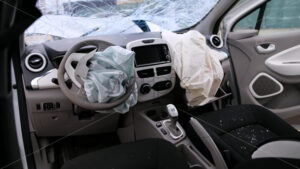 Interior of a crashed car with open airbags after dramatic accident on roads, broken glass - Starpik