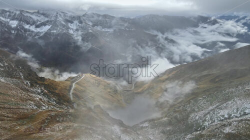 Premium epic stock cinematic video footage – Aerial drone view of winter mountains in Romania with fog and cold snow - Starpik Stock