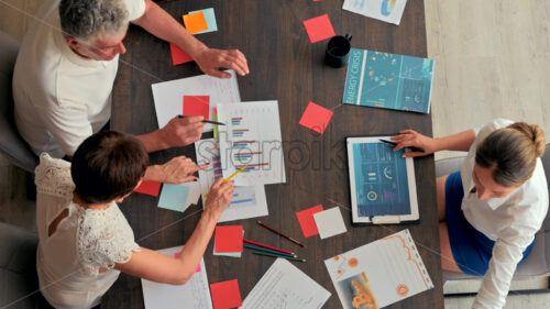 Top view people at the office discussing business charts at a table - Starpik Stock