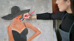 Woman painting a woman in hat at a watercolor workshop - Starpik Stock