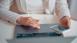 Woman working on notebook and mobile phone - Starpik