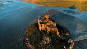 Premium cinematic stock video footage – Aerial drone view of Mont-Saint-Michel at sunset in Normandy, France. Water of the English Channel - Starpik Stock