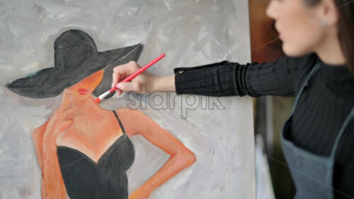Video - Woman painting a woman in hat at a watercolor workshop