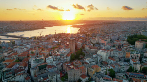 Aerial drone view of Istanbul at sunset, Turkey. Multiple residential buildings around the Galata tower, Golden Horn waterway on the background - Starpik