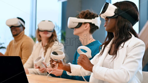 Business conference in VR in an office. Multiracial group of people using VR glasses and controllers, gadgets on the table. Slow motion - Starpik