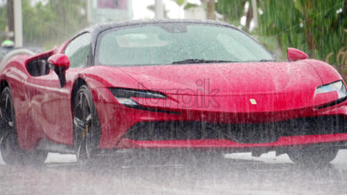Cannes, France – September 20, 2023: View of a parked red Ferrari SF90 Stradale in the rain - Starpik