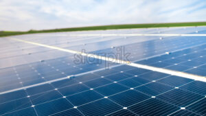 Close view of multiple solar panels on the roof of a manufacturing building in nature. Ecology thematics - Starpik