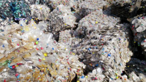 Multiple cubes of compressed transparent plastic garbage at waste recycling factory in open air - Starpik
