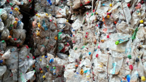 Multiple stacks of compressed transparent plastic garbage at waste recycling factory in open air. Slow motion - Starpik