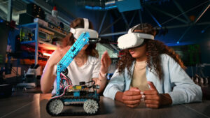 Two young women in VR glasses doing experiments in robotics in a laboratory. Robot on the table - Starpik
