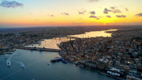 Video – Aerial drone view of Istanbul at sunset, Turkey. Multiple residential buildings, mosques, Galata and Metro bridges over the Golden Horn waterway with floating ships - Starpik Stock