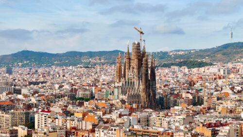 Video – Aerial drone view of Sagrada Familia in city downtown. Famous residential districts around, greenery - Starpik Stock