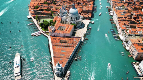 Video – Aerial drone view of Venice, Italy. Water channels with multiple floating and moored boats, historical city centre with Santa Maria della Salute and other old buildings and narrow streets - Starpik Stock