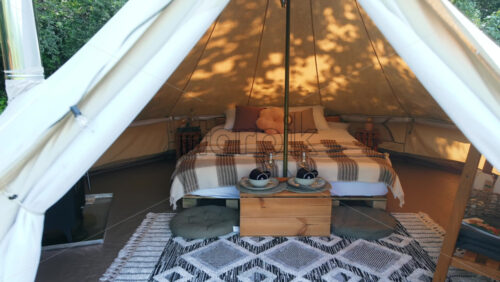 Video - Aerial drone view of entering a glamping tent in the middle of nature