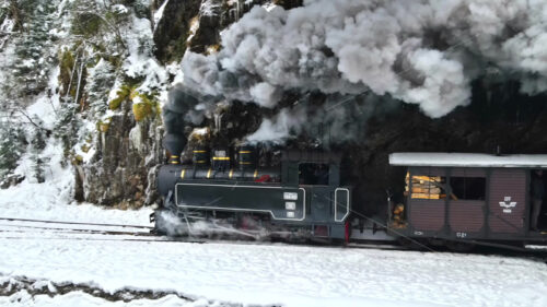 Video – Aerial drone view of old Mocanita steam train in Maramures, Romania, driving in snow in mountains - Starpik Stock