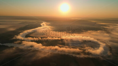 Video - Premium stock cinematic video footage - Aerial drone view of fog over a windy Nistru river at sunrise with red sky in Moldova
