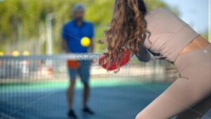 Woman and a man playing pickleball. Outdoor court. Slow motion - Starpik