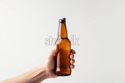A hand holding a beer bottle on a white background - Starpik Stock