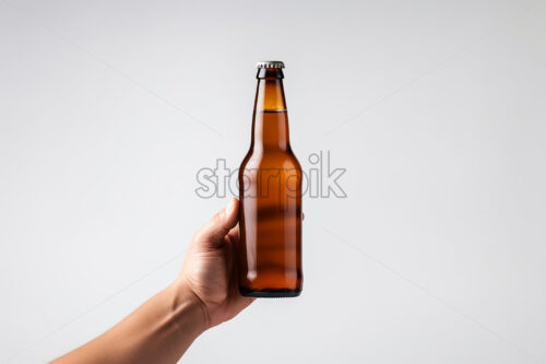 A hand holding a beer bottle on a white background - Starpik Stock