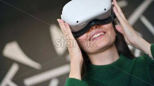 A young woman is excited while wearing VR glasses. Slow motion - Starpik Stock