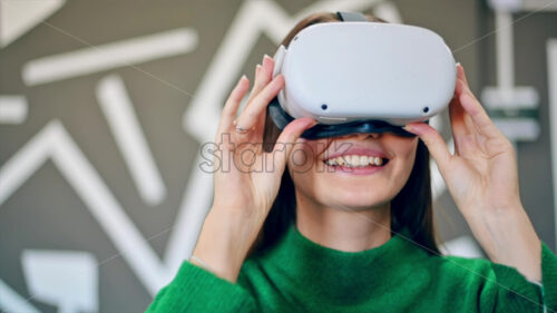 A young woman is excited while wearing VR glasses. Slow motion virtual reality - Starpik Stock