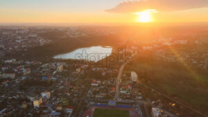 Aerial drone cinematic view of Chisinau. Panorama view of multiple buildings, roads and bare trees, park and a lake. Good weather with setting sun. Moldova - Starpik Stock