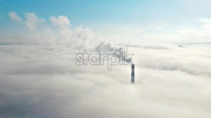 Aerial drone view of Chisinau. Tube of the thermal station with smoke coming out above the low clouds. Visible buildings. Moldova - Starpik Stock