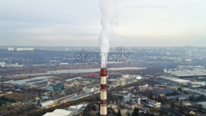 Aerial drone view of Chisinau. Tube of the thermal station with smoke coming out. Cityscape on the background. Cloudy weather. Moldova - Starpik Stock