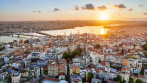 Aerial drone view of Istanbul at sunset, Turkey. Multiple residential buildings around the Galata tower, Golden Horn waterway on the background - Starpik Stock