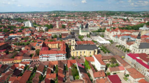 Aerial drone view of Oradea, Romania. View of the city downtown Unirii Square with multiple historical and buildings made in classic style, greenery - Starpik Stock