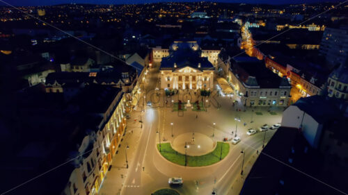Aerial drone view of Oradea downtown at night, Romania. Crisul Repede river, State Theatre with people coming out, illumination - Starpik Stock