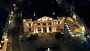 Aerial drone view of Oradea downtown at night, Romania. State Theatre with people coming out, illumination - Starpik Stock