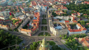 Aerial drone view of Timisoara, Romania. View of the Orthodox Cathedral and Victory Square with historical buildings and greenery around - Starpik Stock