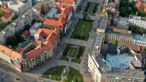 Aerial drone view of Timisoara at sunset, Romania. View of the Victory Square with multiple walking people and historical buildings around - Starpik Stock