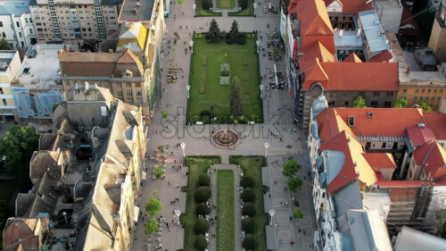 Aerial drone view of Timisoara at sunset, Romania. View of the Victory Square with multiple walking people and historical buildings around, Orthodox Cathedral - Starpik Stock