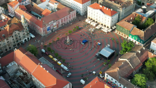 Aerial drone view of Timisoara at sunset, Romania. View of the city downtown, Freedom Square with people and multiple historical buildings around - Starpik Stock