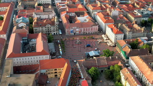 Aerial drone view of Timisoara at sunset, Romania. View of the city downtown, Freedom Square with people and multiple historical buildings around - Starpik Stock