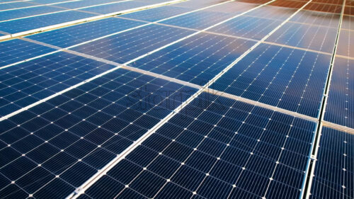 Aerial drone view of blue solar panels installed on a high efficient energy factory roof - Starpik Stock