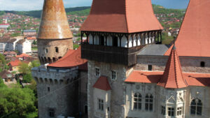 Aerial drone view of the Corvin Castle facade located in Hunedoara, Romania. Greenery and buildings around - Starpik Stock