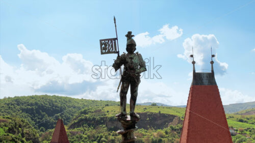 Aerial drone view of the Corvin Castle located in Hunedoara, Romania. Knight statue located on the top of a tower, greenery on the background - Starpik Stock