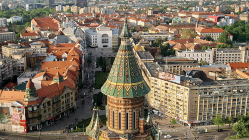 Aerial drone view of the Orthodox Cathedral dome with historical buildings and greenery around in Timisoara, Romania - Starpik Stock