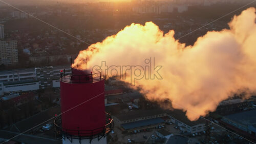 Aerial drone view of thermoelectric tower with white smoke in winter - Starpik Stock
