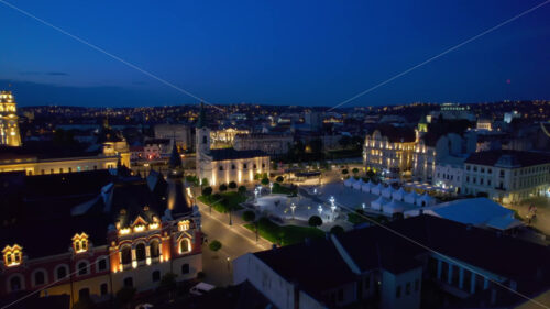 Areal drone view of the Cathedral of St. Nicholas in Oradea downtown at night, Romania. Unirii Square on the background, illumination - Starpik Stock