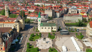 Areal drone view of the Unirii Square in Oradea downtown, Romania. King Ferdinand I statue, Saint Ladislaus Church, Town Hall and other historical buildings - Starpik Stock