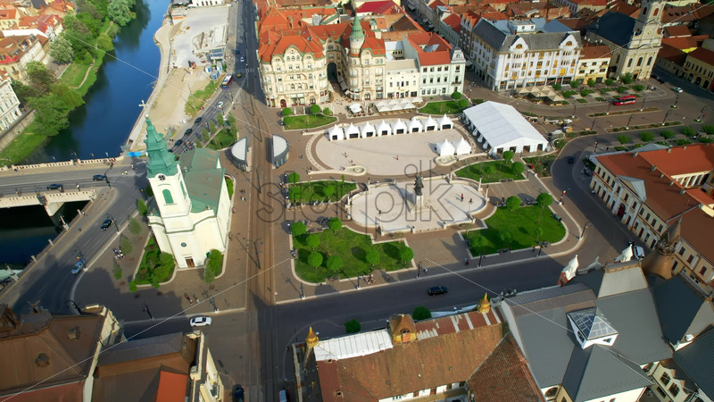 Video - Areal drone view of the Unirii Square in Oradea downtown, Romania. King Ferdinand I statue, Saint Ladislaus Church and other historical buildings, walking people