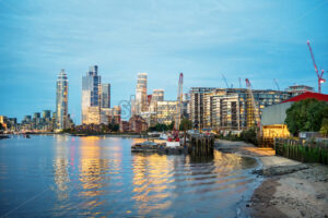 Cityscape of London at evening, United Kingdom. Thames river with financial district with skyscrapers in the distance, illumination - Starpik Stock