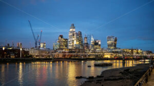 Cityscape of London at evening, United Kingdom. Thames river with financial district with skyscrapers in the distance, illumination - Starpik Stock