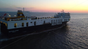 LIVERPOOL, UNITED KINGDOM – MAY 10 2023: Aerial drone vew of Seatruck cargo boat near port at sunset - Starpik Stock