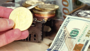Man hand observing a bitcoin golden crypto coin near us dollar bills money and gpu video cards for mining - Starpik Stock