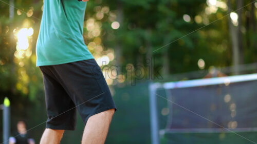 Man playing Pickleball, hitting the ball with a racket on an outdoor court. Slow motion - Starpik Stock